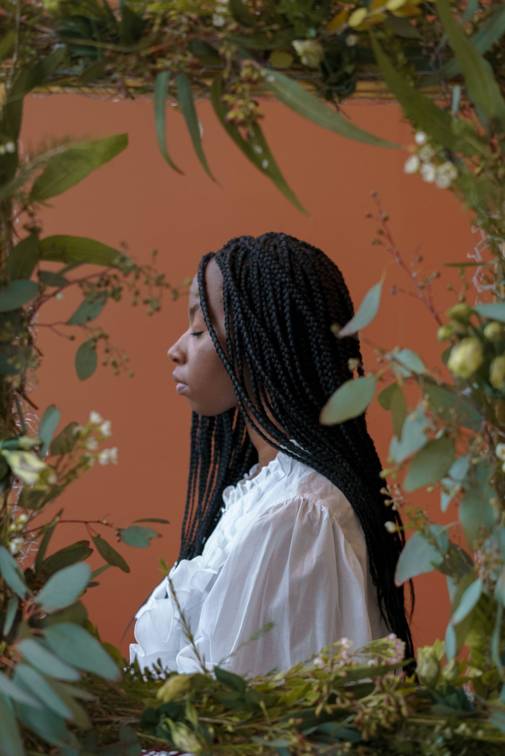 Photo by Dziana Hasanbekava: https://www.pexels.com/photo/confident-black-lady-with-closed-eyes-near-frame-with-plants-7275346/