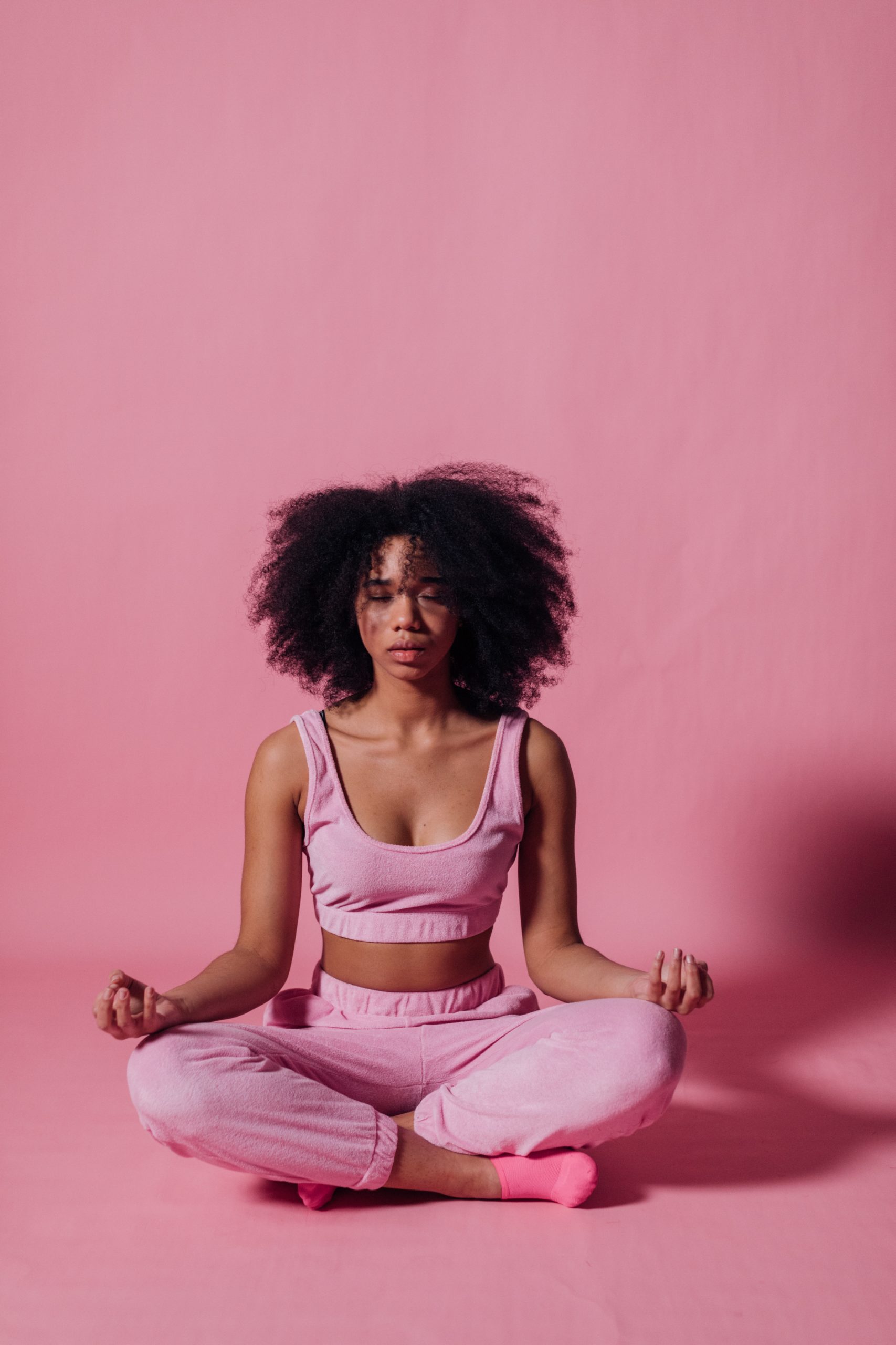 Photo by KoolShooters: https://www.pexels.com/photo/woman-in-pink-crop-top-and-jogging-pants-practicing-yoga-7346634/