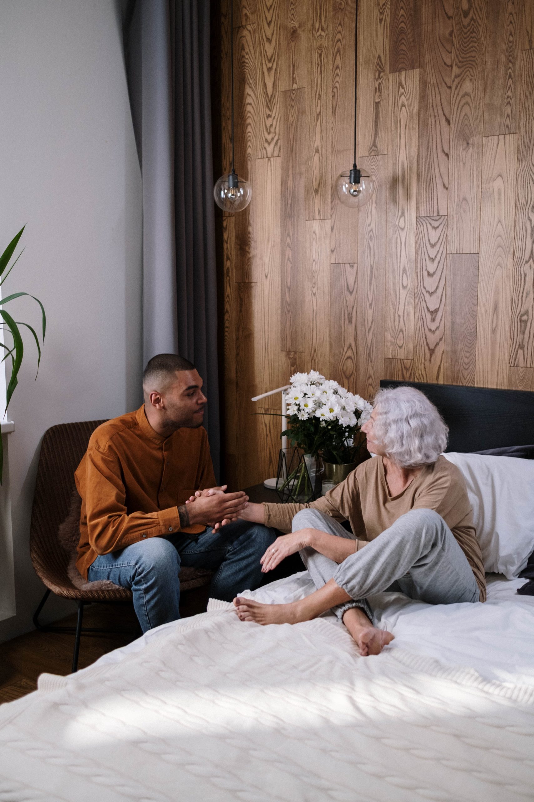 Photo by Ron Lach : https://www.pexels.com/photo/man-in-orange-long-sleeve-shirt-sitting-on-brown-chair-beside-the-bed-8527726/